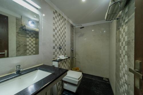een badkamer met een bad, een toilet en een wastafel bij Hotel Tamizh Park in Pondicherry