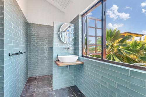 a bathroom with a sink and a window at Boutique Hotel Wanapa in Kralendijk
