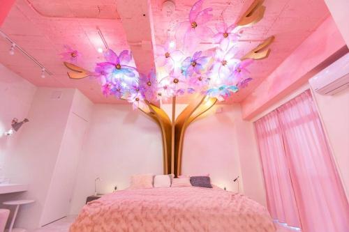 1 dormitorio con un árbol con flores púrpuras en el techo en Moshi Moshi Rooms, en Tokio