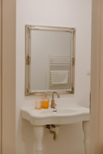 a bathroom with a white sink and a mirror at La Fontaine in Hunedoara