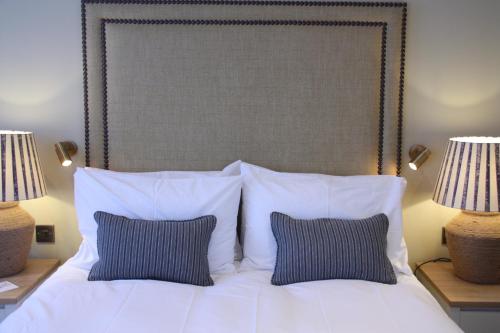 a white bed with two pillows and two lamps at The Bell Hotel, Saxmundham in Saxmundham