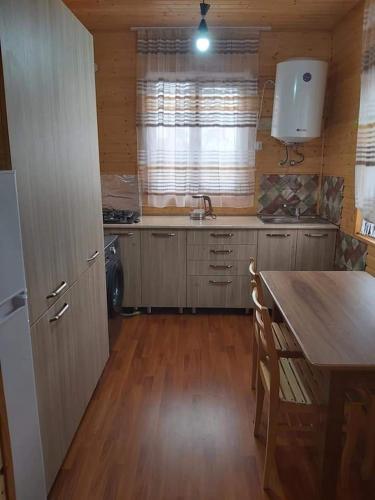 a kitchen with a wooden table and a wooden floor at Wooden House Ashuri in Veltaurtkari