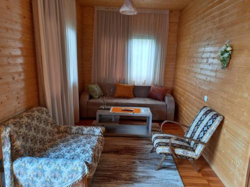 a living room with a couch and a table at Wooden House Ashuri in Veltaurtkari