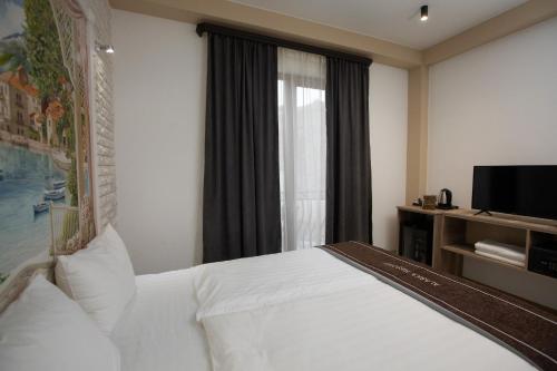 a bedroom with a white bed and a window at Alaska Resort in Tsaghkadzor