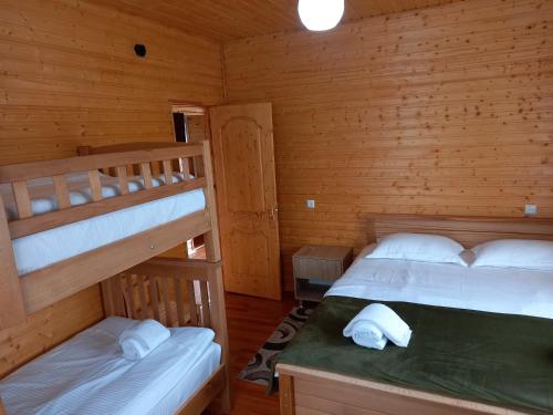 two bunk beds in a room with wooden walls at Wooden House Ashuri in Veltaurtkari
