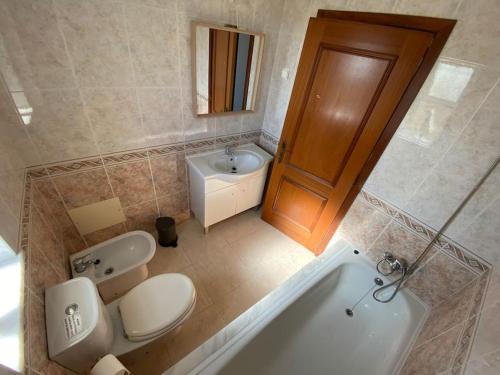 La salle de bains est pourvue de toilettes, d'un lavabo et d'une baignoire. dans l'établissement Apartamento Mimosas, à Albufeira