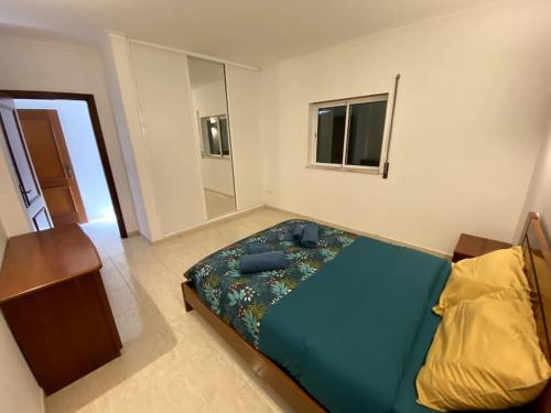 - une petite chambre avec un lit et un miroir dans l'établissement Apartamento Mimosas, à Albufeira