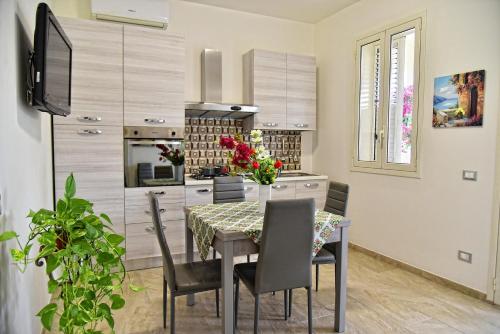 a kitchen with a dining room table and chairs at La Gardenia in Noto Marina
