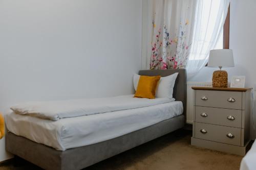 a small bedroom with a bed and a nightstand at La Fontaine in Hunedoara