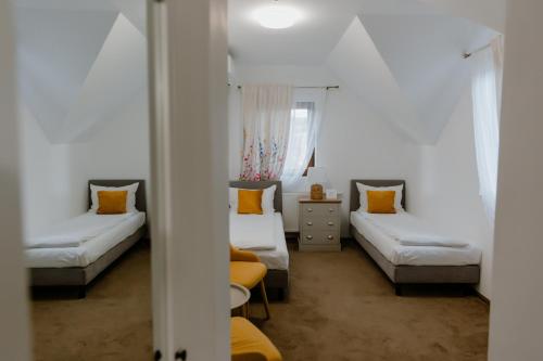 a small room with two beds and a table at La Fontaine in Hunedoara