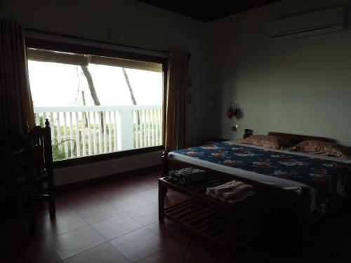 Postel nebo postele na pokoji v ubytování Alleppey Beach Garden