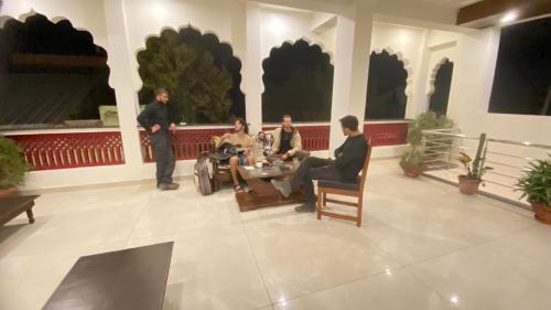 a group of people sitting around a table in a building at Golden Bird Pushkar in Pushkar