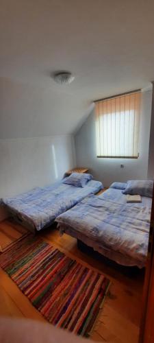 two twin beds in a room with a rug at Smjestaj na selu Stankovic - Pliva in Šipovo