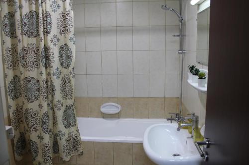 a bathroom with a sink and a shower and a tub at Bright, spacious and cozy studio apartment in Dubai