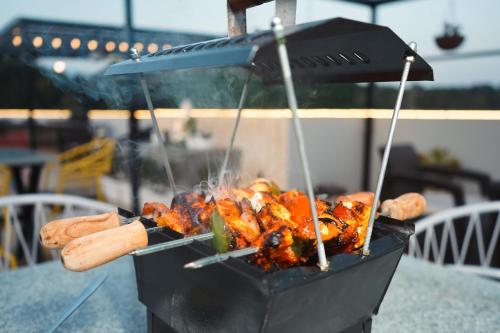 a grill with a bunch of food on it at The Eleganza in Jhājra