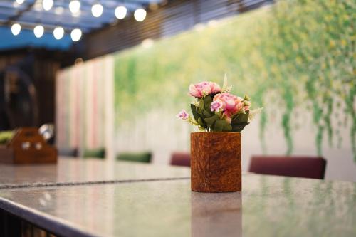 a vase with pink flowers sitting on a table at The Eleganza in Jhājra