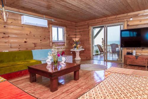 a living room with a couch and a tv and a table at Vibe Naftali Estate in Ramot Naftali