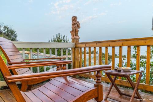 a rocking chair and a statue on a deck at Vibe Naftali Estate in Ramot Naftali