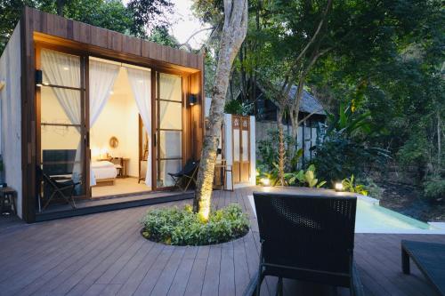 a house with a wooden deck with a tree at Proud Phu Fah Maerim Resort in Mae Rim
