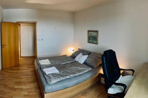 a bedroom with a bed and a chair in it at JASMINE APARTMENT - FREE PARKING - CITY CENTER - SKIBUS - TATRALANDIA 5km in Liptovský Mikuláš