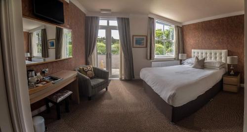 una camera d'albergo con letto, scrivania e sedia di Owlswood Apartments a Edinbain