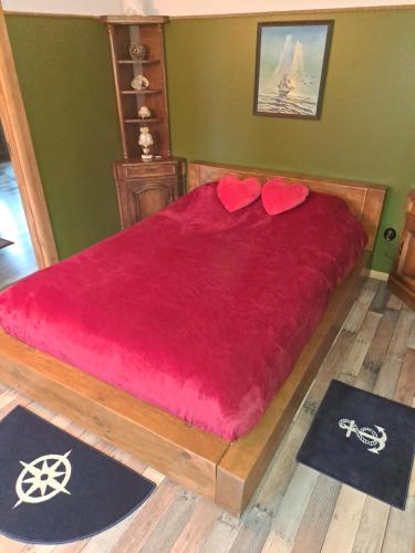 a bedroom with a red bed with two red pillows at Yacht Club in Liepāja