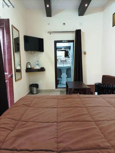 a bedroom with a large bed and a sink at Foreigners Inn in Varanasi