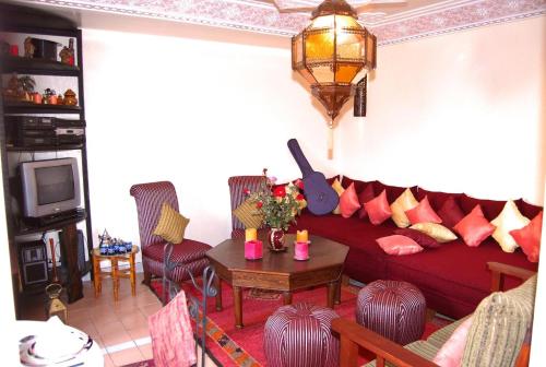 ein Wohnzimmer mit einem roten Sofa und einem Tisch in der Unterkunft Chez Peyo in Marrakesch