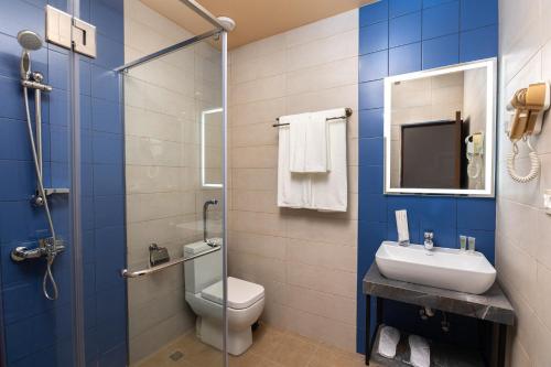 a bathroom with a toilet and a sink and a shower at Alaska Resort in Tsaghkadzor