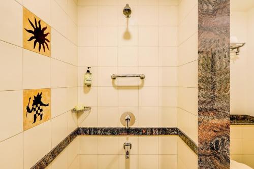 a bathroom with a shower and a sink at Lemon Tree Hotel, East Delhi Mall, Kaushambi in Ghaziabad