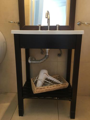 a black bathroom sink with a basket under it at Departamento Alvarado in Salta