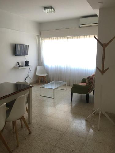 sala de estar con ventana, mesa y sillas en Departamento Alvarado en Salta