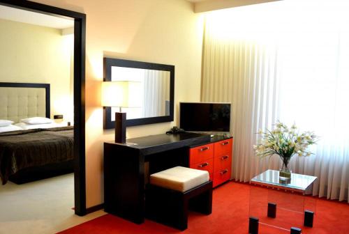 a bedroom with a bed and a desk with a mirror at Hotel Astory Plzeň in Plzeň