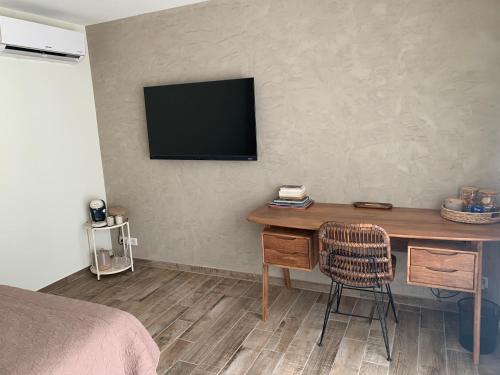 1 dormitorio con escritorio y TV en la pared en Chambre d hôtes Cabries Calas 5 min gare TGV Aix, en Cabriès