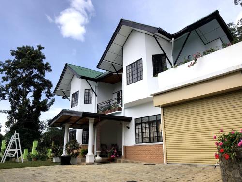 a white house with a yellow garage at Hill Crest Holiday Bungalow in Diyatalawa