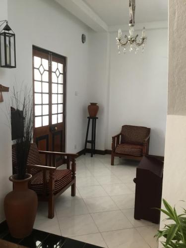 a living room with chairs and a chandelier at Hill Crest Holiday Bungalow in Diyatalawa