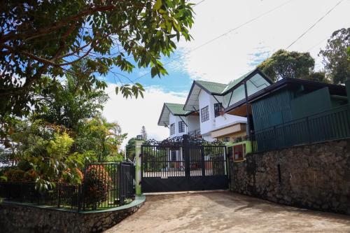a house with a black gate in front of it at Hill Crest Holiday Bungalow in Diyatalawa