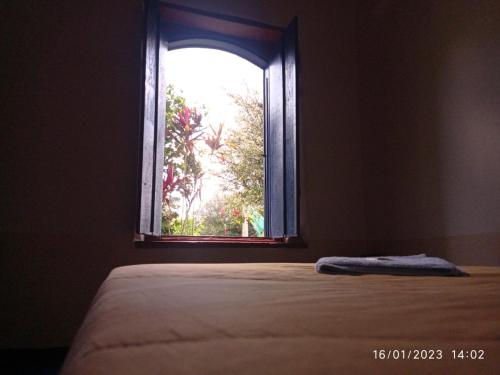 a bedroom with a bed and a window at Bonserá do Madeira in Lavras