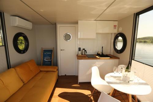 a living room with a couch and a table and a kitchen at Houseboat in Wolin