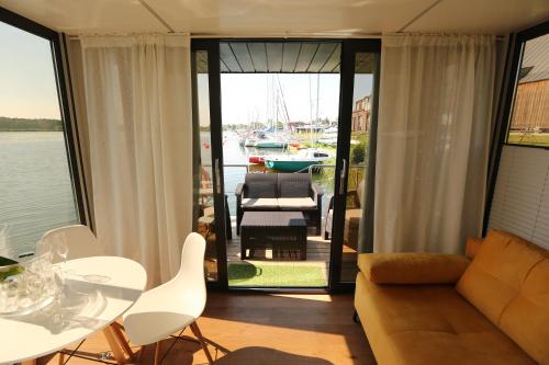 uma sala de estar com um sofá, uma mesa e cadeiras em Houseboat em Wolin