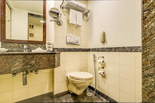 a bathroom with a toilet and a sink at Lemon Tree Hotel, East Delhi Mall, Kaushambi in Ghaziabad