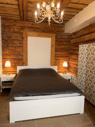 a bedroom with a white bed and wooden walls at Karlova Manor Apartments in Tartu
