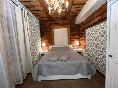 a bedroom with a bed and a chandelier at Karlova Manor Apartments in Tartu