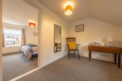 a bedroom with a mirror and a desk and a bed at The Town House in Woodbridge