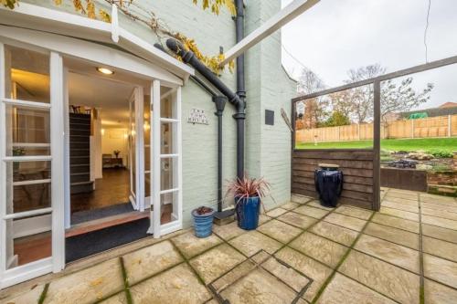 a patio with two potted plants next to a house at The Town House in Woodbridge