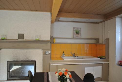 a kitchen with a table and a sink and a fireplace at La Batisse in Saint-Laurent