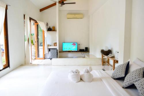 a white room with two white shoes on the floor at Proud Phu Fah Maerim Resort in Mae Rim