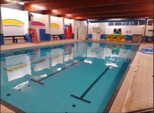 a large swimming pool with blue water in a building at LA07 Oceanview in Morecambe