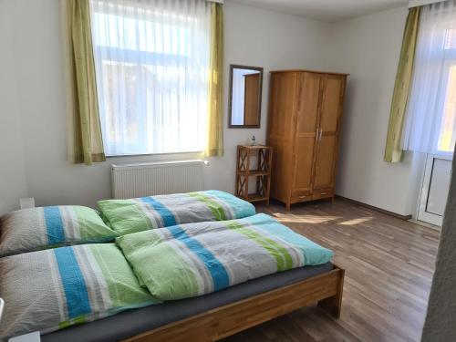 1 dormitorio con 1 cama y 2 ventanas en Seevilla Wietjes Whg 3, en Baltrum