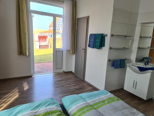 Habitación con cama, lavabo y baño. en Seevilla Wietjes Whg 3 en Baltrum